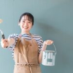 ローラーと塗料を持って笑顔でヤル気を出している女性